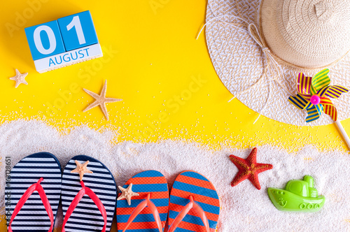 August 1st. Image of august 1 calendar with summer beach accessories and traveler outfit on background. Summer vacation concept