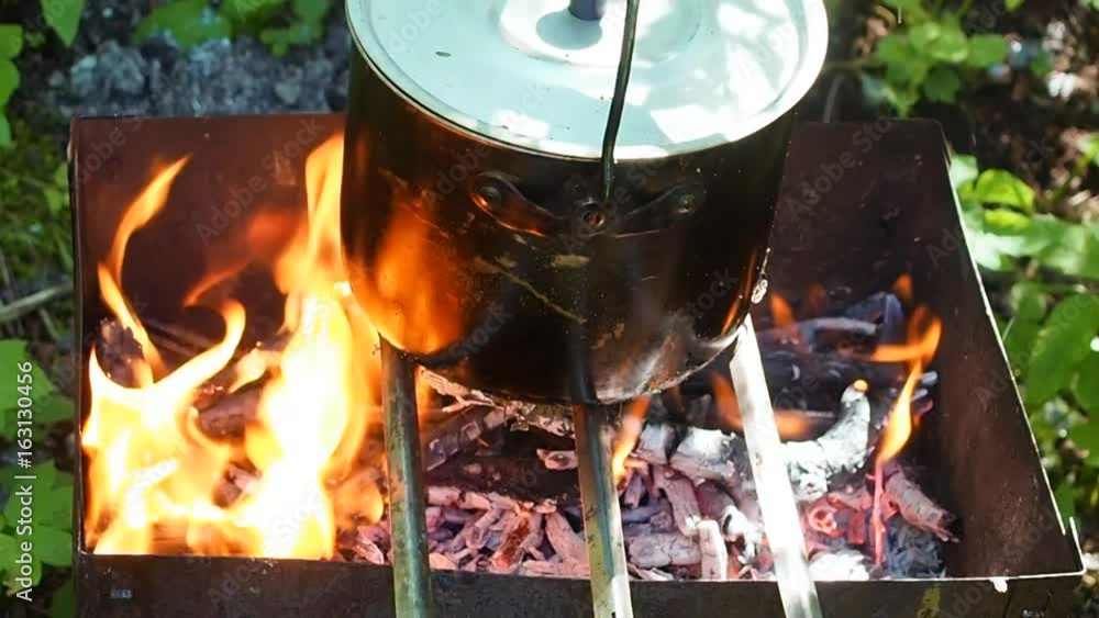 Camping pot on fire during a halt on the nature. Tourist food in the forest. Hiking in the wild. Camping pot on fire during a halt on the nature. Tourist food in the forest. Hiking in the wild.