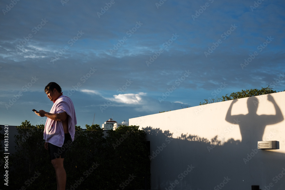 fat young man with fit strong shadow, intention to dieting concept fat young man with fit strong shadow, intention to dieting concept