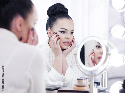Fototapeta Naklejka Na Ścianę i Meble -  Woman in the mirror woman putting on make up.