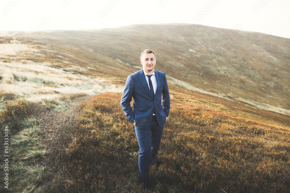 Young handsome man posing at sunset on mountain Young handsome man posing at sunset on mountain