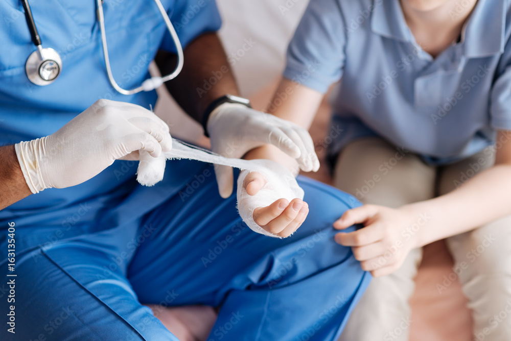 Close up of male hands while dressing disabled palm Close up of male hands while dressing disabled palm