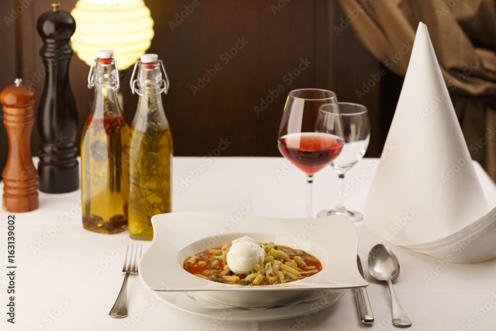 Runner bean soup arranged in a plate, Wineglass in background, Traditional dish in elegant setting, Selective focus with soft light Runner bean soup arranged in a plate, Wineglass in background, Traditional dish in elegant setting, Selective focus with soft light