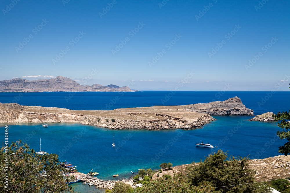 Bay and shore of the city of lindos. Blue water and wonderful beaches of Rhodes island.