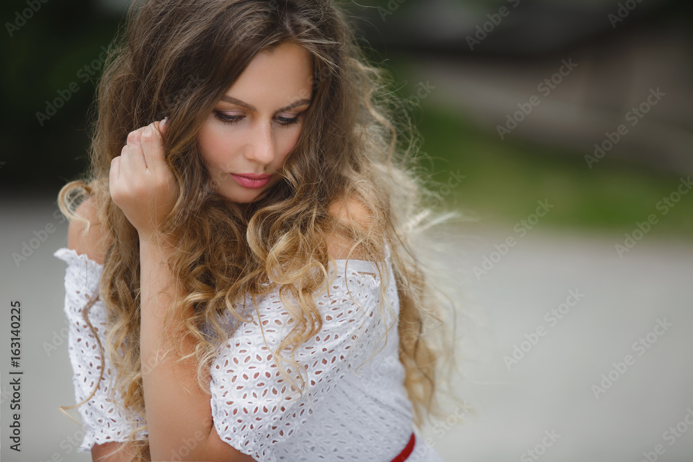 Close up portrait of a beautiful curly hair woman. Beautiful woman outdoors in summer park. Young girl in the nature Close up portrait of a beautiful curly hair woman. Beautiful woman outdoors in summer park. Young girl in the nature