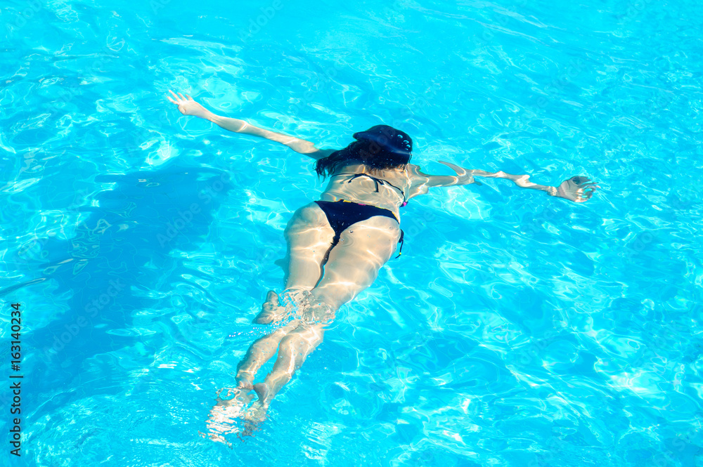 Young Woman Swimming Underwater in Swimming Pool. Summer Vacation