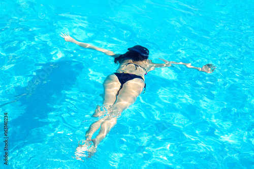 Young Woman Swimming Underwater in Swimming Pool. Summer Vacation