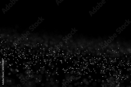Falling dust cloud design . Particles cloud background  wallpaper with copy space. Rain  snow fall concept . Freeze motion of white powder coming down  isolated on black  dark background.