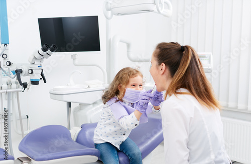 Little girl looking in dentist mouth