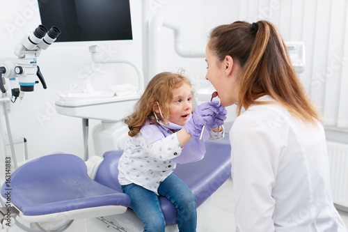 Little girl looking in dentist mouth
