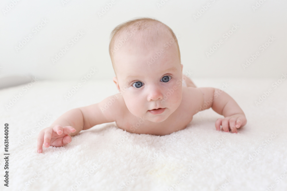 Cute 4 months baby girl in diaper lying on belly at home Cute 4 months baby girl in diaper lying on belly at home