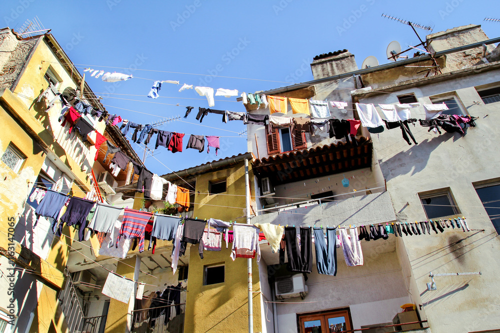 Laundry hanging on a clothes line on an old city building. Hanging