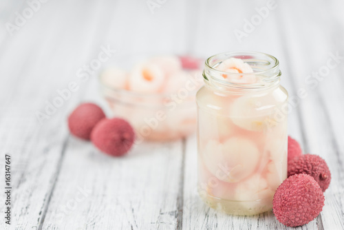 Wooden table with Preserved Lychees (selective focus) photo