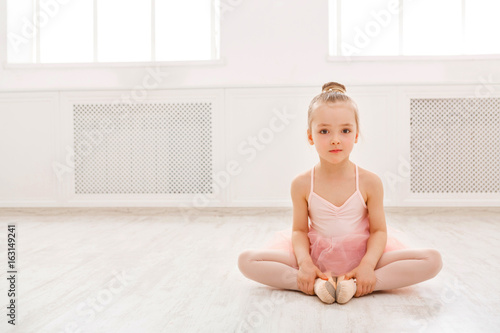 Portrait of little ballerina on floor, copy space photo
