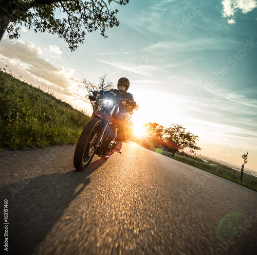 Man riding sportster motorcycle during sunset. © Lukas Gojda