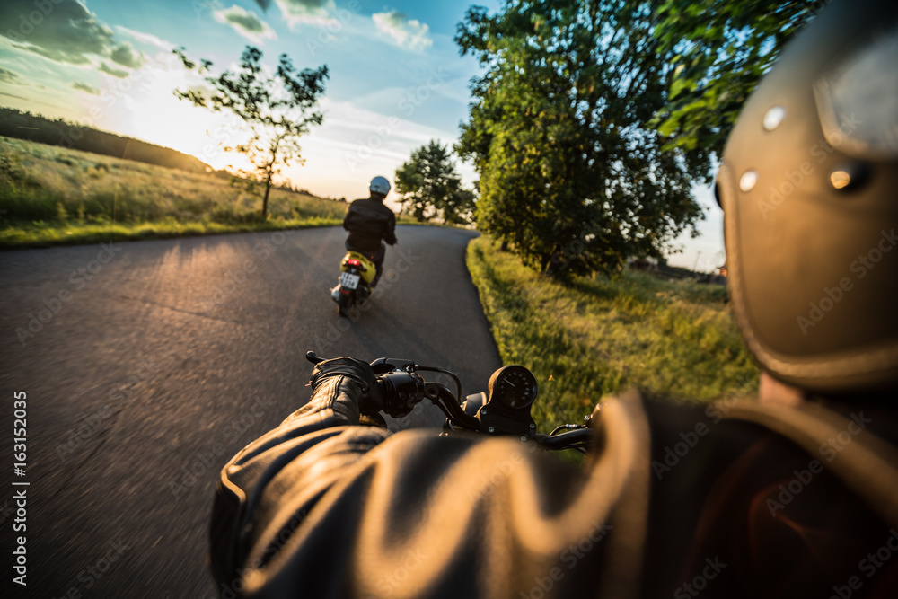 Fototapeta premium Man riding sportster motorcycle during sunset.