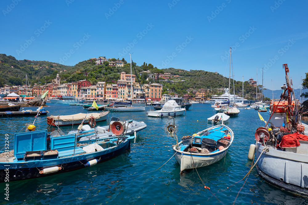 Portofino typical beautiful village with colorful houses and small harbor with fishing boats in Italy