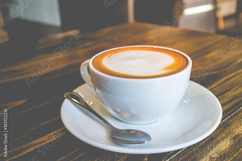Fotografie hot coffee mocha with foam milk in vintage cafe(vintage effect)