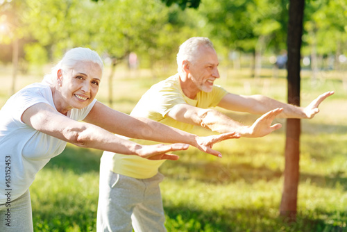 Joyful senior couple enjoying sport exercises together