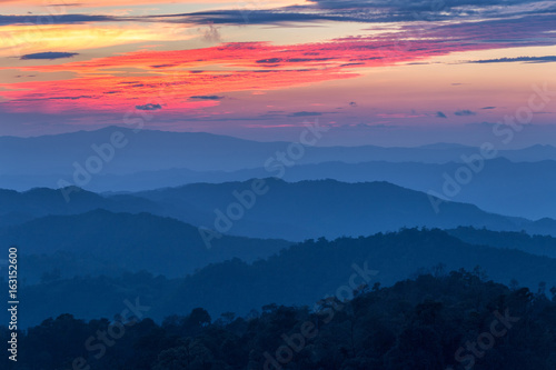 Layer of mountains in the mist at sunset time with burning sky, Nan Province, Thailand