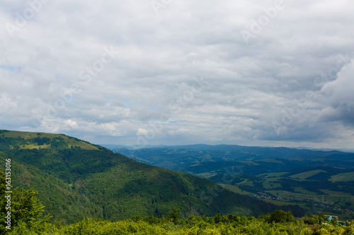 Summer landscape in mountains and the dark blue sky with clouds