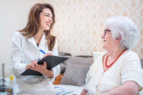 Home healthcare nurse talking to senior patient. photo