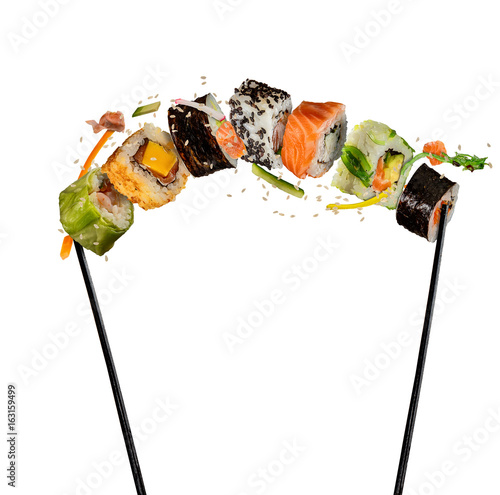 Sushi pieces placed between chopsticks on white background