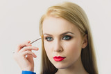 Model applying eye shadow with makeup brush