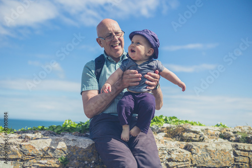 Grandfather playing with grandchild by the sea
