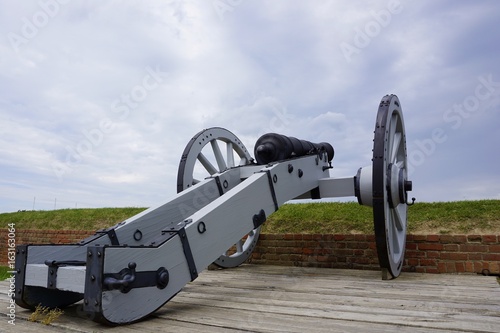 Old medieval wooden cannon on the wheel pointed out and aiming