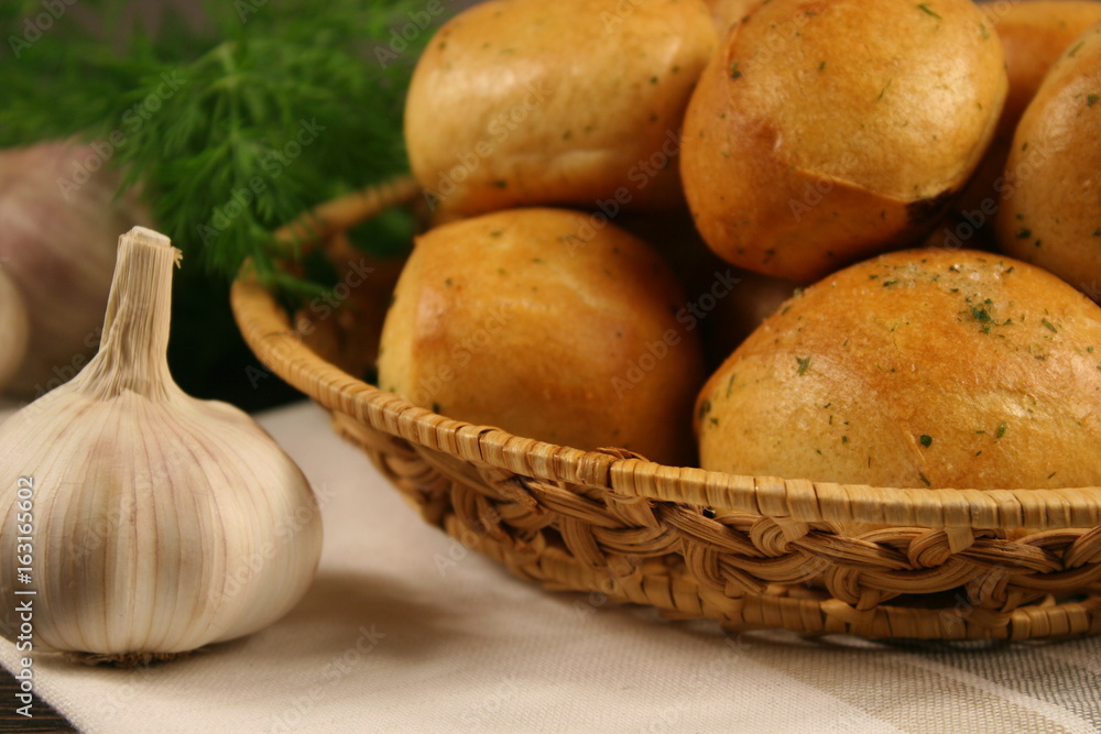 Homemade buns with garlic and dill on wooden table Homemade buns with garlic and dill on wooden table
