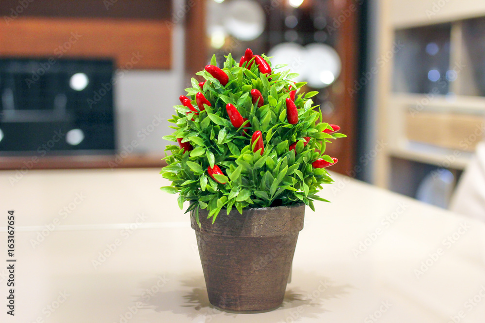 Red chili pepper in a pot on the kitchen table Red chili pepper in a pot on the kitchen table