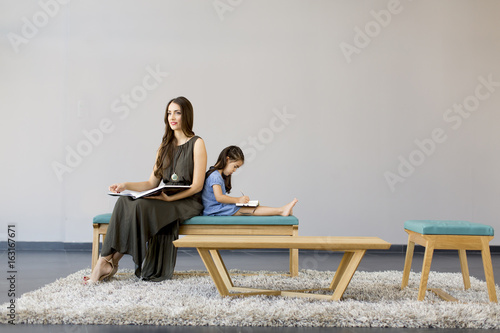 Little girl and mom sit in ...