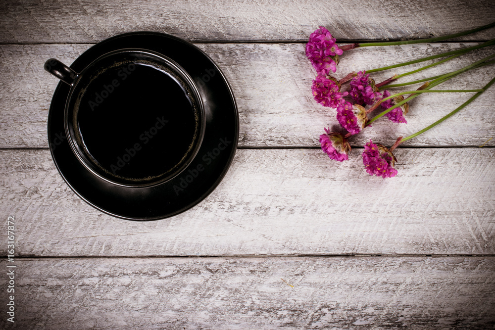 Fototapeta premium flowers and coffee cup on wooden table with copy space. celebration template concept.