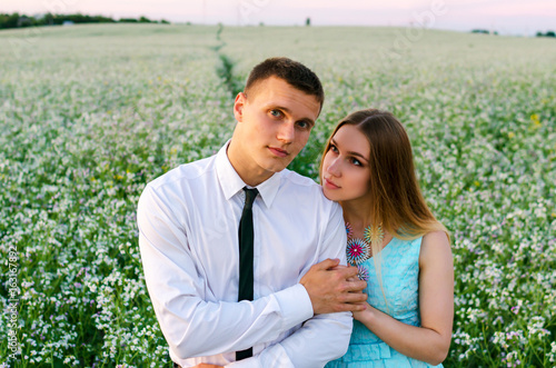 Romantic couple running in field holding hands. Couple enjoying outdoors in the field. Young loving couple in field