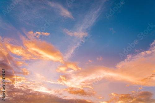 sunset / sun rise sky with rays of yellow and red light shining clouds and sky background and texture