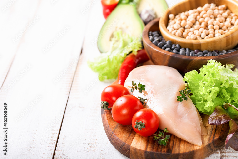 Raw chicken and fresh vegetables on a table. Healthy food. Selective focus. Copy space