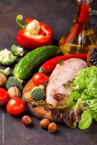 Fototapeta Naklejka Na Ścianę i Meble -  Raw chicken and fresh vegetables on a table. Healthy food. Selective focus. Copy space