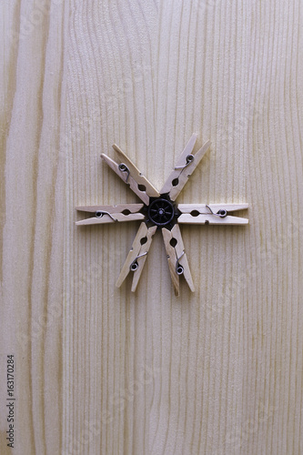 Clothes peg on a light wooden background