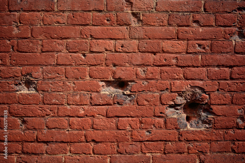Background old brick wall with holes of bullets
