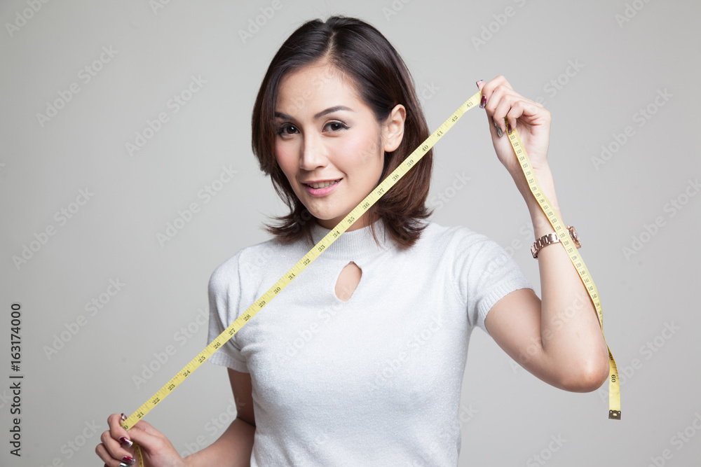 Young Asian woman with measuring tape. Young Asian woman with measuring tape.