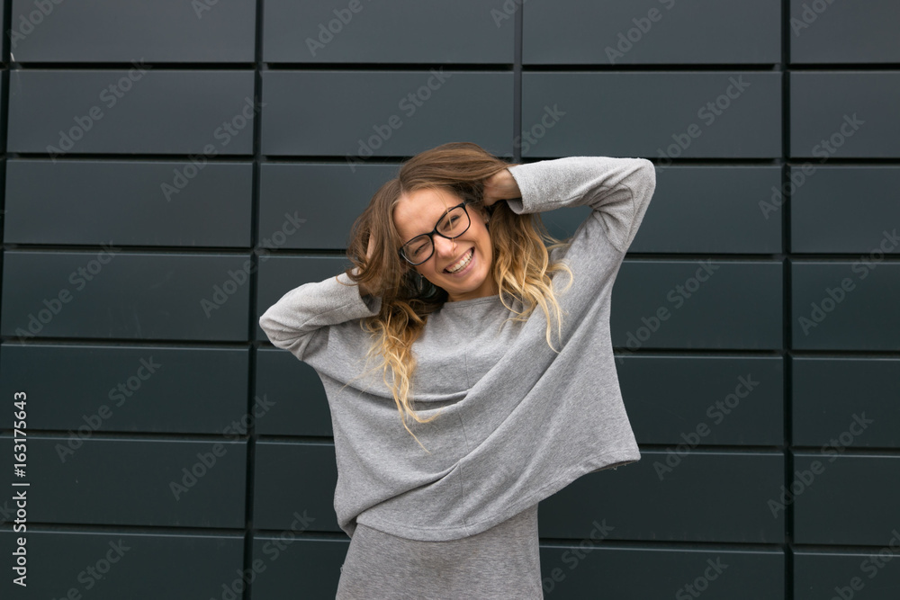Fototapeta premium Large portrait of a girl with glasses on a gray background