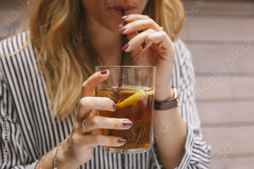 woman drinking iced tea with a straw photo