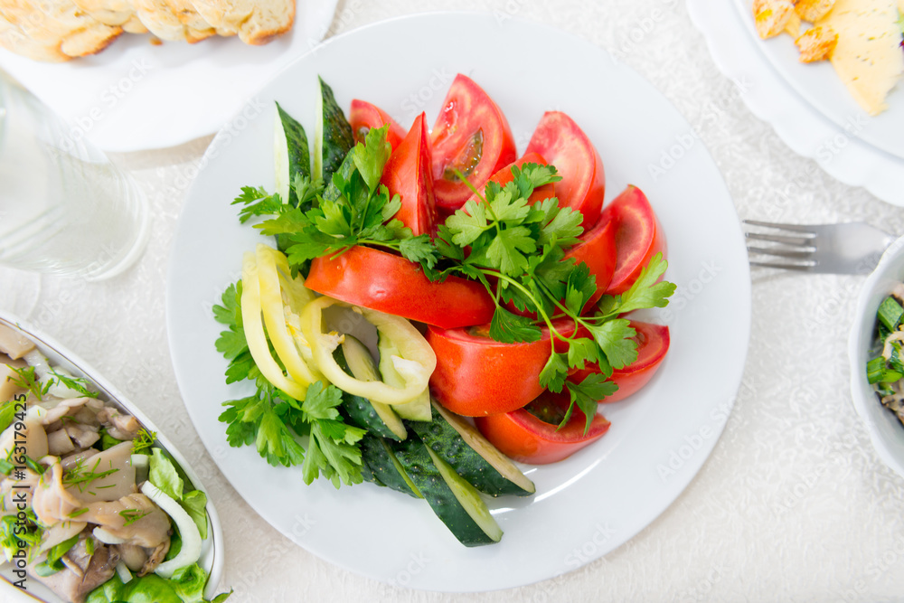Bright, fragrant, fresh vegetable sliced from tomato, cucumber, pepper and greens close-up.