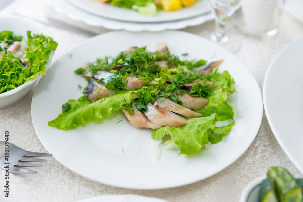 Juicy, fragrant herring, sliced and decorated with greenery close-up. Juicy, fragrant herring, sliced and decorated with greenery close-up.