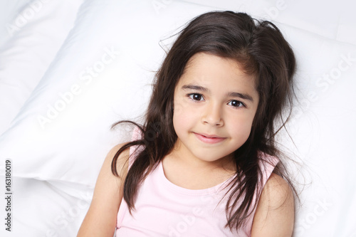 Beautiful little girl sleeping in white bed