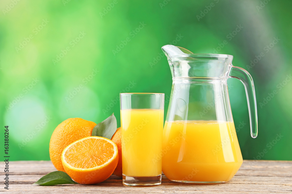 Glass jug with orange juice on wooden table Glass jug with orange juice on wooden table
