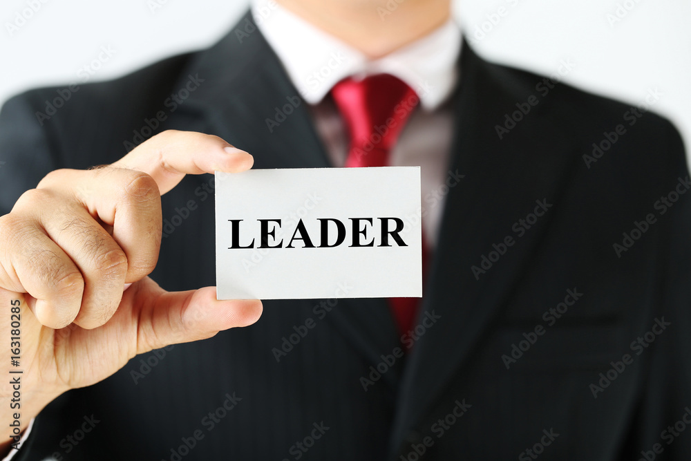 Businessman holding card with word Leader Businessman holding card with word Leader
