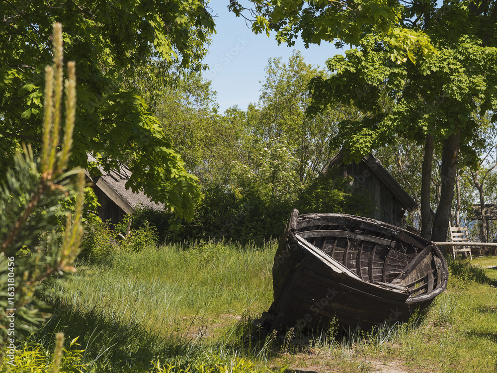 Old grungy wooden fishing boat and old style houses in the background. Old grungy wooden fishing boat and old style houses in the background.