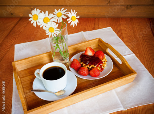 Waffles with strawberry jam and fresh strawberry and coffee on wooden background